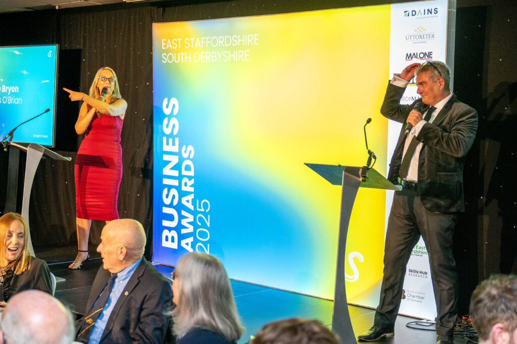 Two speakers present at East Staffordshire South Derbyshire Business Awards 2025 ceremony on stage.